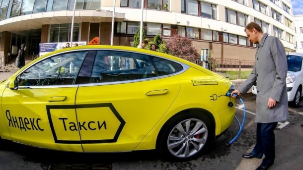 Gelber Tesla mit russischer Aufschrift "Yandex Taxi"