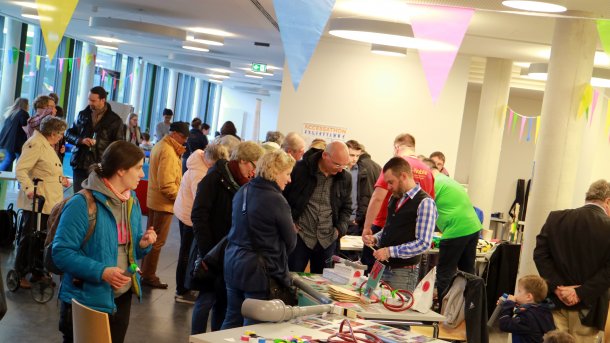 Blick in die Hochschule Rhein-Waal während der Mini Maker Faire 2019 mit vielen Menschen an verschiedenen Ständen.