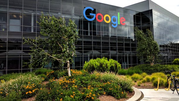 Glaspalast mit Aufschrift "Google", davor Grünraum und ein Fahrrad