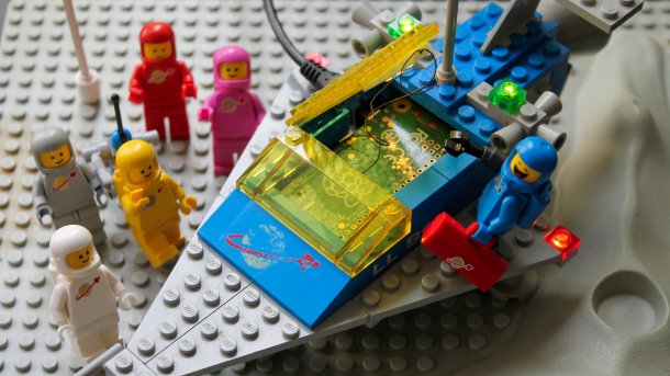 Lego-Figuren neben einem Raumschiff mit Lichtern.