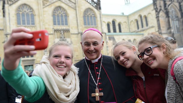 Jugendliche schießen Selfie mit einem Bischof