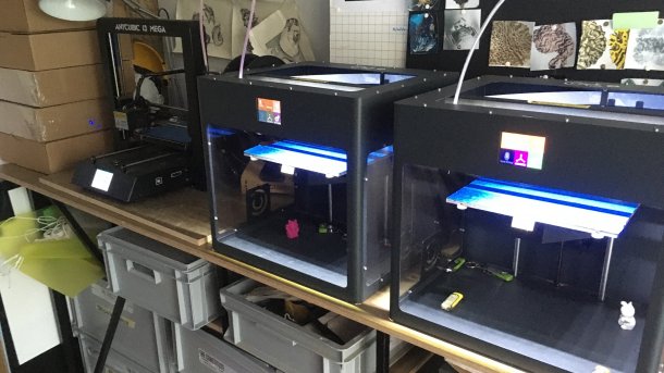 Mehrere 3D-Drucker stehen nebeneinander.