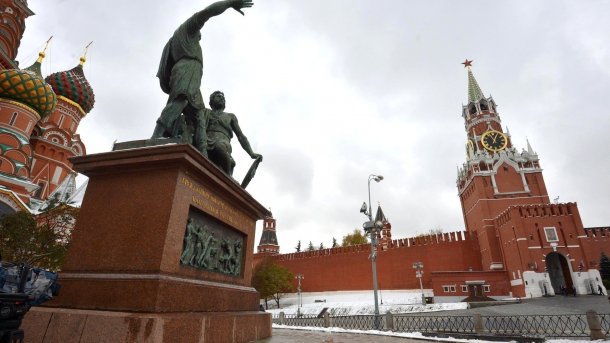 Bronzestatue am Roten Platz in Moskau vor dem Erlöserturm des Kreml und der Basilius-Kathedrale (am linken Bildrand) 