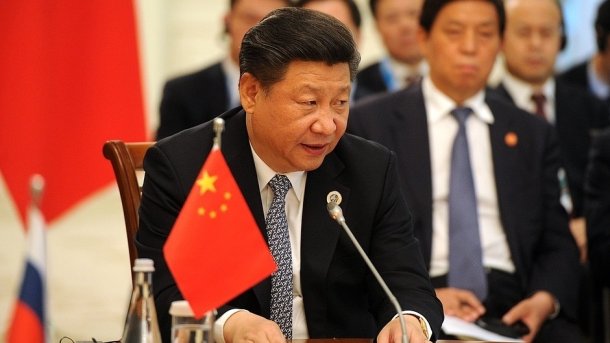 Xi Jinping an Tisch mit Wimpel der VR China