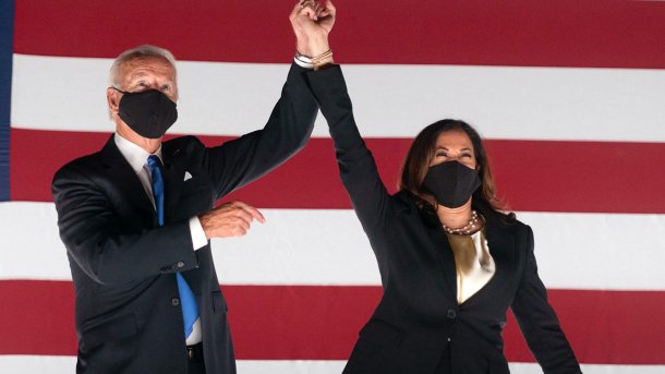 Joe Biden und Kamala Harris jubeln vor riesiger US-Flagge