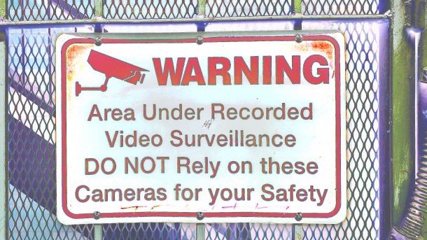 Schild "WARNING - Area under recorded video surveillance. DO NOT rely on these cameras for your safety."