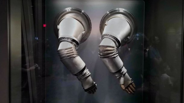 Metallene Arme eines Raumanzug-Prototypen hängen in einer Vitrine