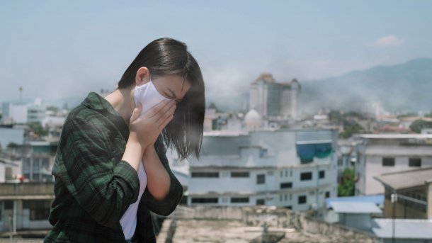 Frau schützt sich mit Maske vor Smog