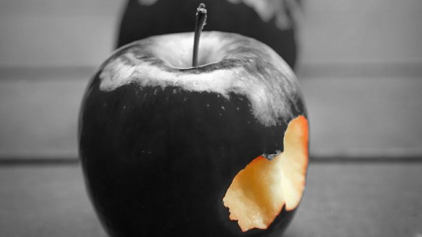 Angebissener schwarzer Apfel