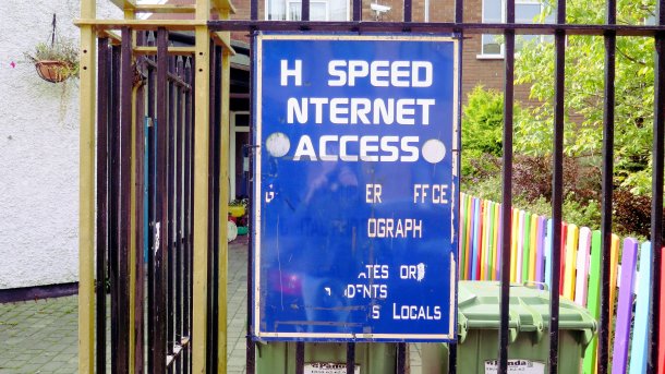Blaues Schild mit weißer Schrift bewirbt "H Speed nternet Access" - bei den weiteren Angaben auf dem Schild fehlen wesentlich mehr Buchstaben