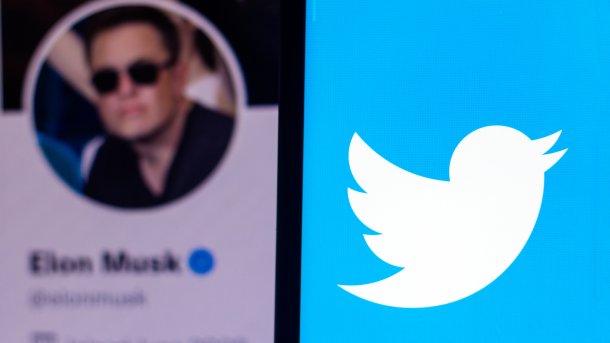 Elon Musks Konterfei auf einem Handybildschirm, im Hintergrund das Twitter-Logo