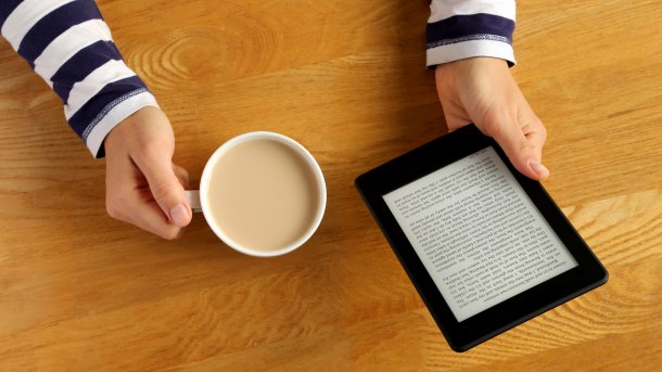 Woman,Reading,A,Novel,On,A,Tablet,And,Drinking,Her, E-Book, Kindle, Reader