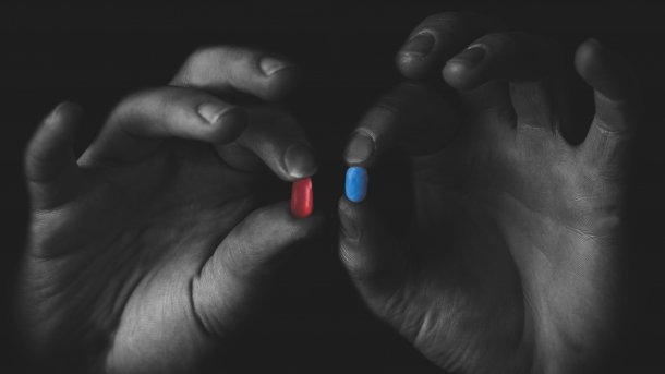 Man,Holding,Red,And,Blue,Pills,In,Hand,Isolated,On