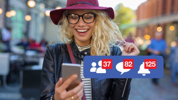 Eine Frau lächelt in ihr Handy neben Facebook-Benachrichtigungen
