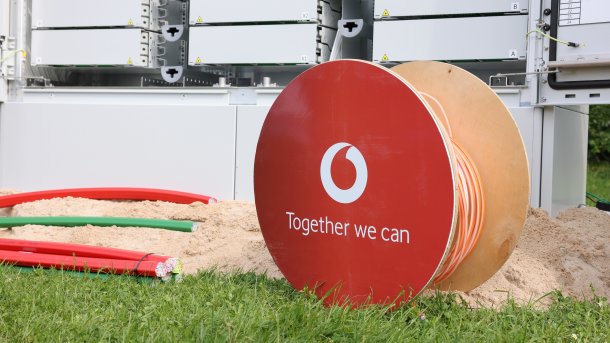 Eine Kabelrolle mit dem Logo von Vodafone und Leerrohre auf einer Baustelle.