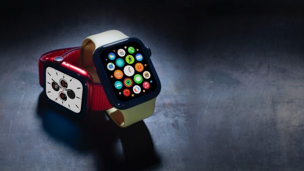Zwei Apple Watches mit leuchtenden Bildschirmen