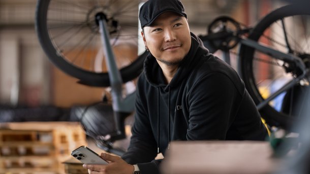 Mechaniker mit Smartphone vor einem Fahrrad