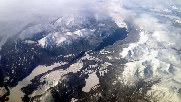 Luftaufnahme zeigt verschneite Berge und Seen