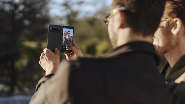 2 Männer machen mit einem Klapphandy ein Selfie