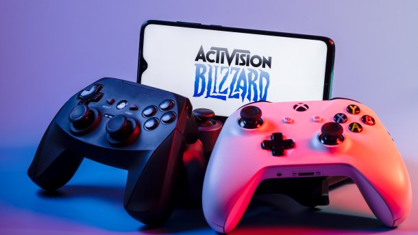 Ein Bildschirm zeigt das Activision-Blizzard.Logo; davor ein Playstation-Controller sowie ein Xbox-Controller