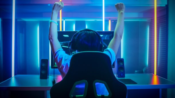 Spieler streckt Arme hoch vor dem Monitor