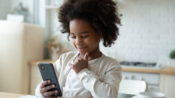 Smiling,Little,African,American,Girl,Watch,Distant,Class,On,Smartphone,
