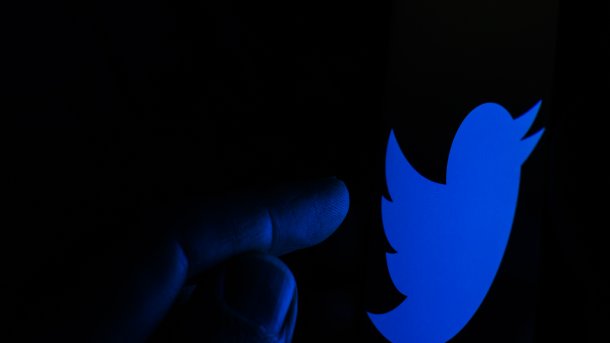 Finger tippt im Dunkeln auf Twitter-Logo