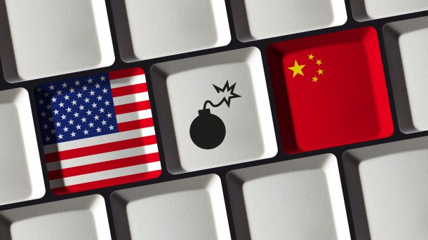 Computertasten mit Flaggen der USA und Chinas, dazwischen eine mit einer Bombe