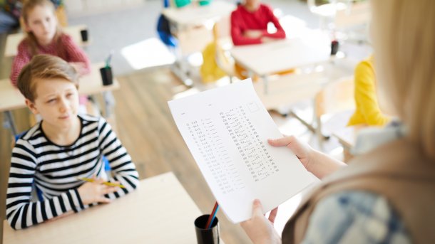 Oral,Questioning,At,Math,Class:,Teacher,Holding,Paper,With,Algebraic