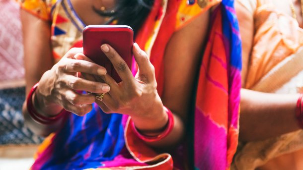 Frau in traditioneller Kleidung aus Indien am Smartphone