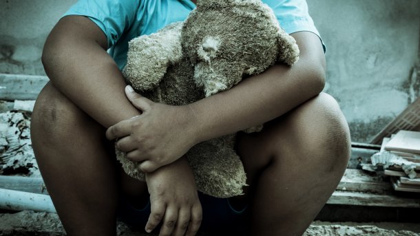 Teddybär im Arm eines Kindes