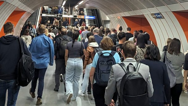 Viele Menschen, die in einer Wiener U-Bahn-Station zum Stiegenaufgang drängen, fotografiert von hinten
