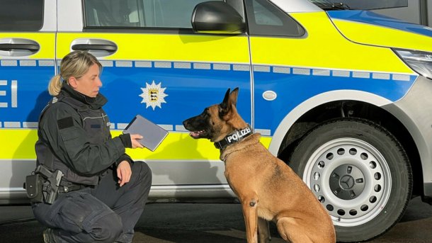 Polizistin mit Tablet und einem Polizeihund