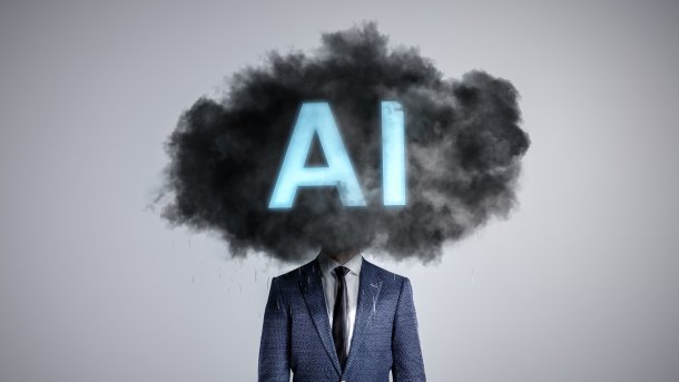 Person in Anzug und Krawatte; der Kopf der Preson ist durch eine dunkle Wolke ersezt, in der die Buchstaben "AI" aufleuchten