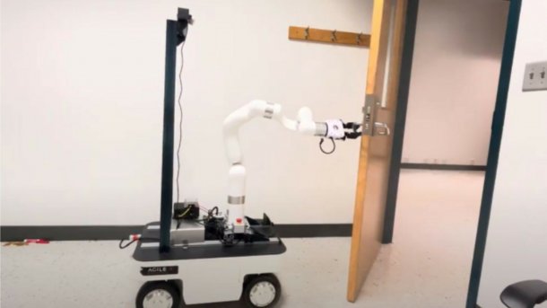 Ein vierrädriger Roboter öffnet mit einem Greifarm eine Tür.