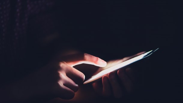Hände am Smartphone im Dunkeln