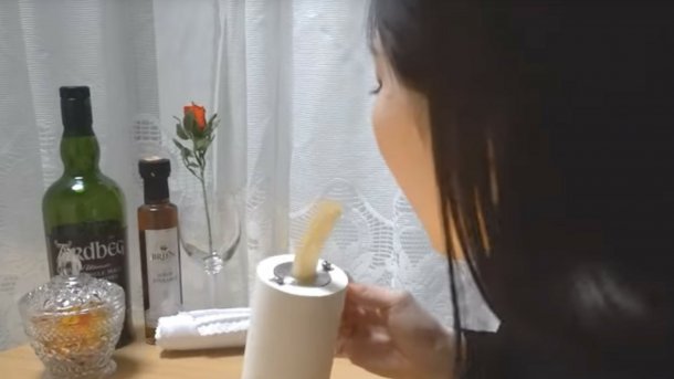 Ein beweglicher essbarer Teil wird in einer Tasse von einer Frau gegessen.