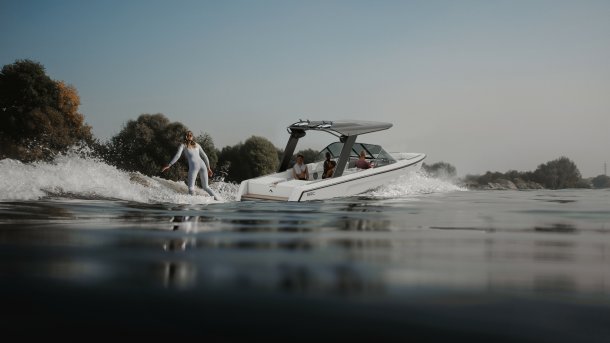 Das Bild zeigt das Elektroboot Arc Sport mit einem Wakeboarder im Schlepptau.