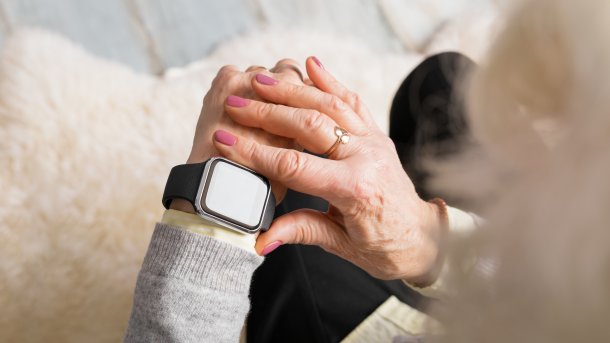 Das Bild zeigt eine Smartwatch am Handgelenk einer älteren Frau.