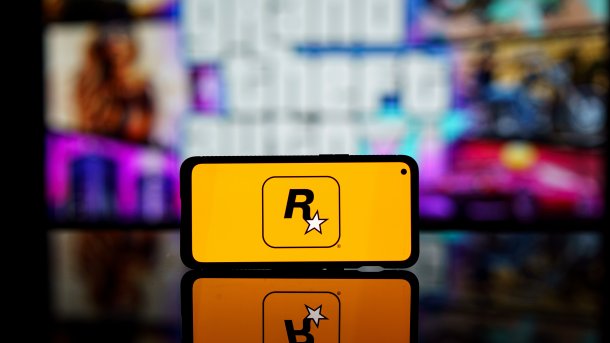 Smartphone mit Rockstar-Logo vor Display mit unscharfem GTA-Schriftzug