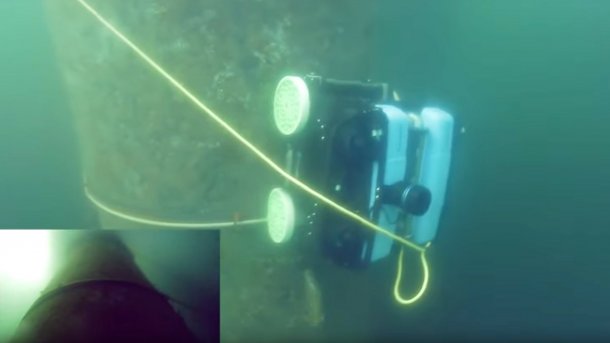 Das Bild zeigt einen Crawfish-Unterwasserroboter, der unter Wasser vertikal einen Röhre hochfährt.