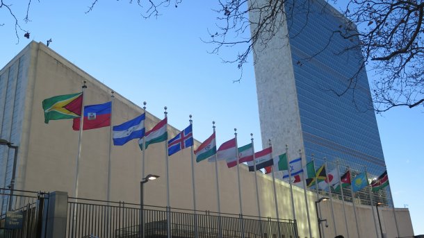 UN-Gebäude in New York, im Vordergrund Flaggen der Staaten Guyana bis Kenia (in alphabetischer Reihenfolge)