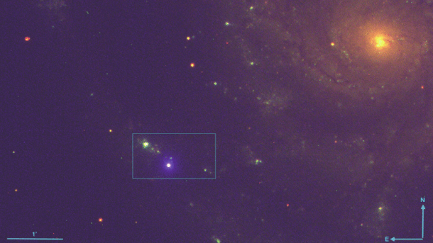 Dunkles Bild einer Galaxie und ein heller blauer Punkt