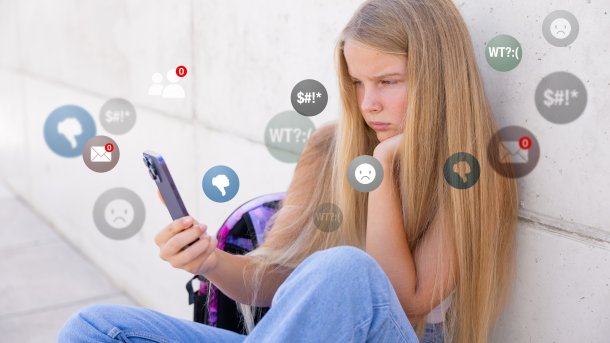 An der Wand sitzt ein Mädchen mit Smartphone, das von negativen Symbolen in Nachrichten umgeben ist