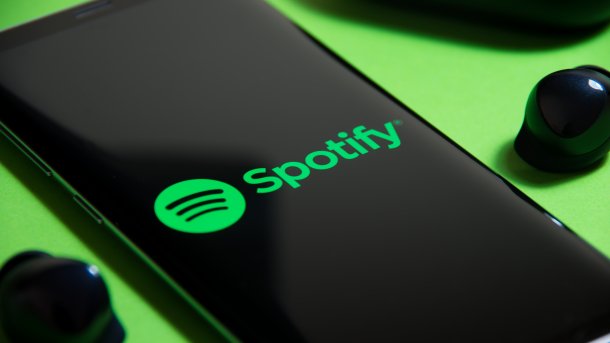 Spotify-Logo auf Handy vor grünem Hintergrund