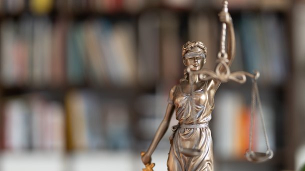 Justitia vor Bücherregal