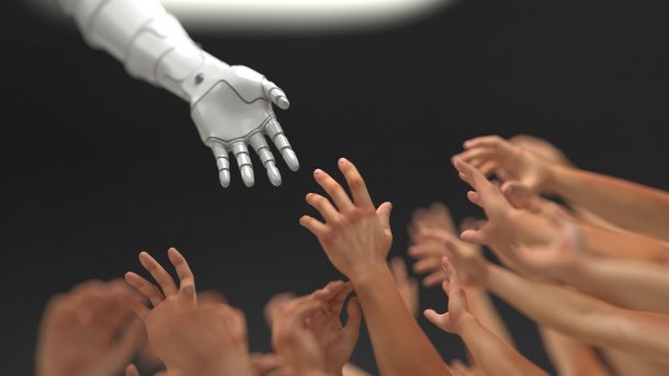 Eine Roboterhand streckt sich menschlichen Händen entgegen