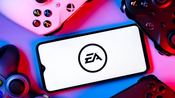 Handy mit EA-Logo neben verschiedenen Gamepads