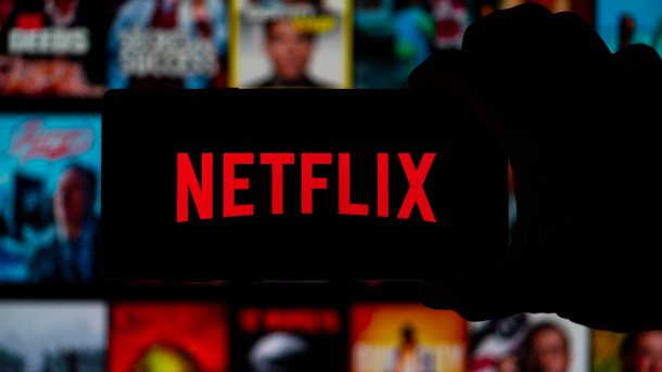 Netflix-Logo auf Bildschirm vor DVD-Hüllen