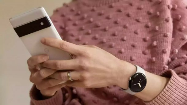 Frau hält Google Pixel Smartphone in der Hand, am Arm eine Pixel Watch